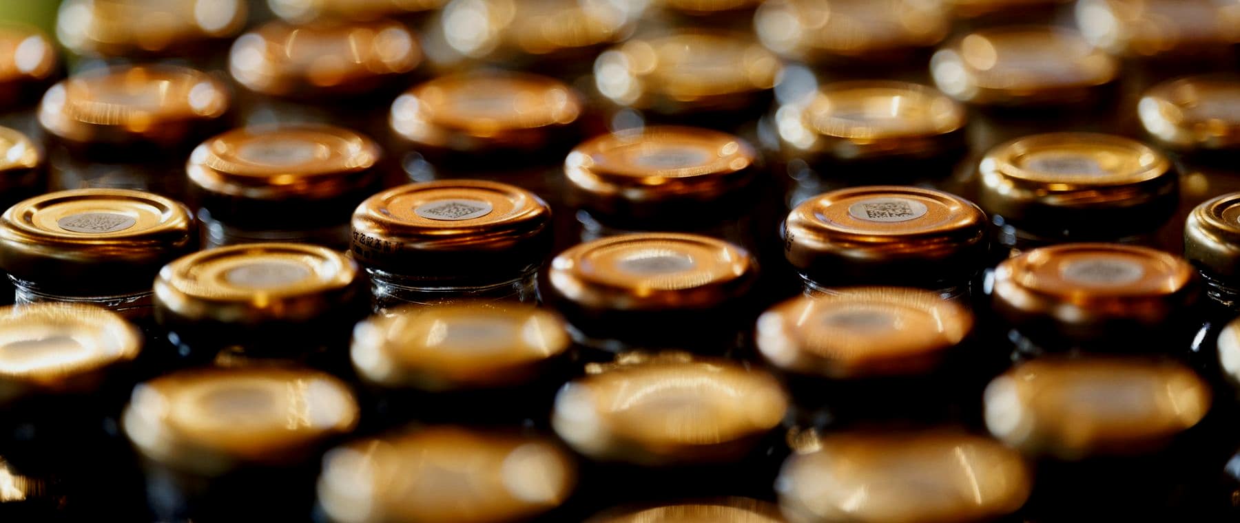 Close-up of rows of metal closures on a packaging line